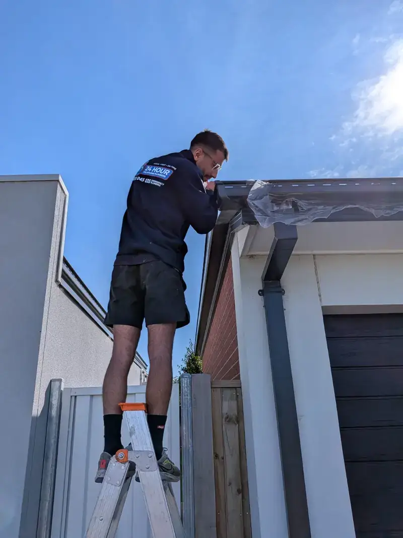 Roof plumber working on gutter in Brighton